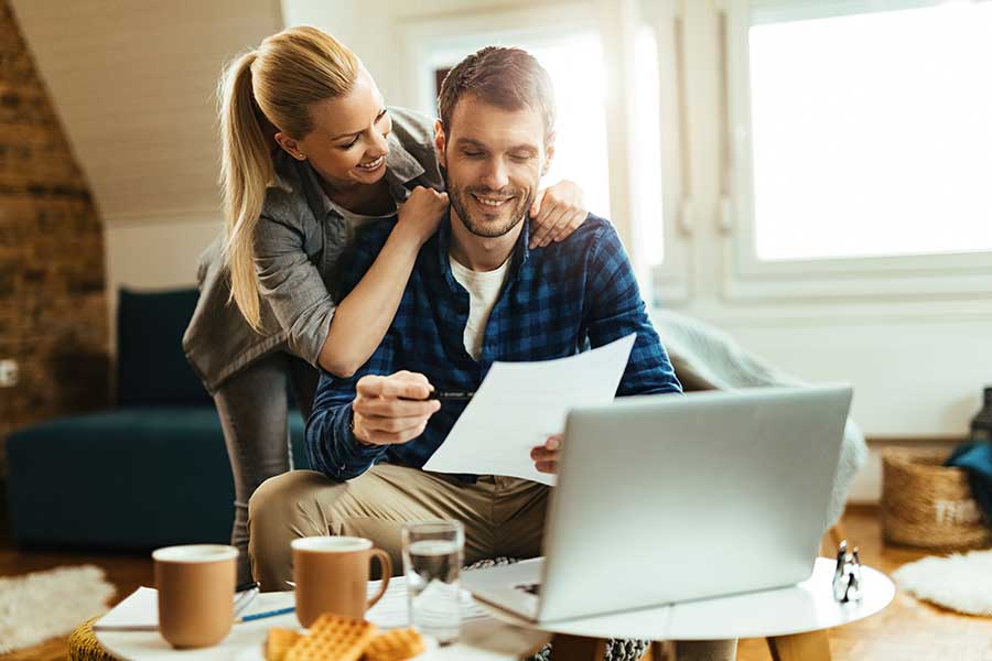A couple looking at a loan approval on a laptop